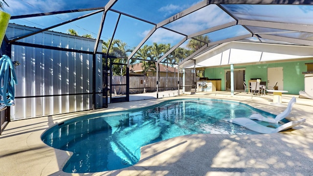 view of pool featuring a lanai, a patio area, and exterior kitchen