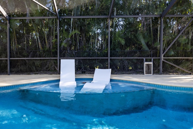 view of swimming pool featuring a lanai