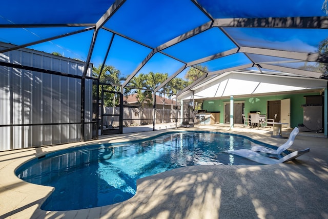 view of swimming pool with glass enclosure and a patio