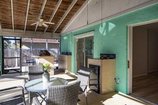 sunroom featuring lofted ceiling with beams, ceiling fan, and wood ceiling