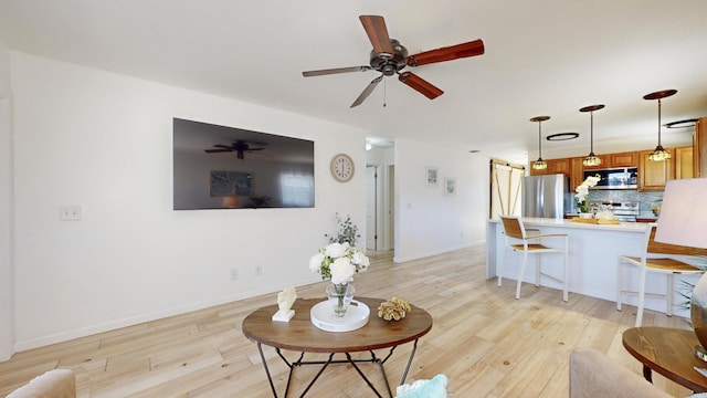 living room with light hardwood / wood-style floors and ceiling fan