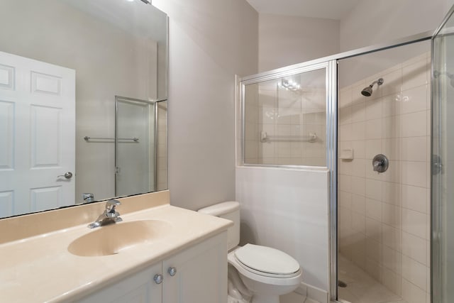 bathroom with a stall shower, vanity, and toilet