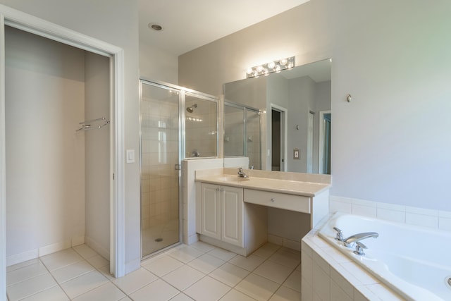 bathroom with a stall shower, vanity, a garden tub, and tile patterned floors