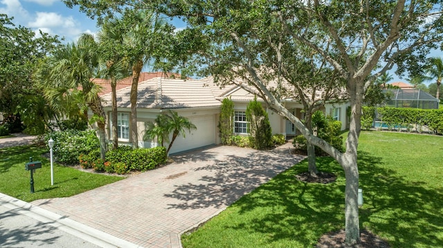 view of front of house with an attached garage, a front lawn, decorative driveway, and a tiled roof