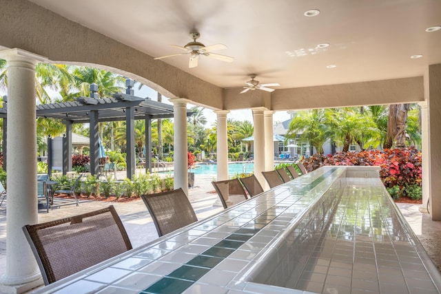 view of patio / terrace with outdoor dining space, ceiling fan, a community pool, and a pergola