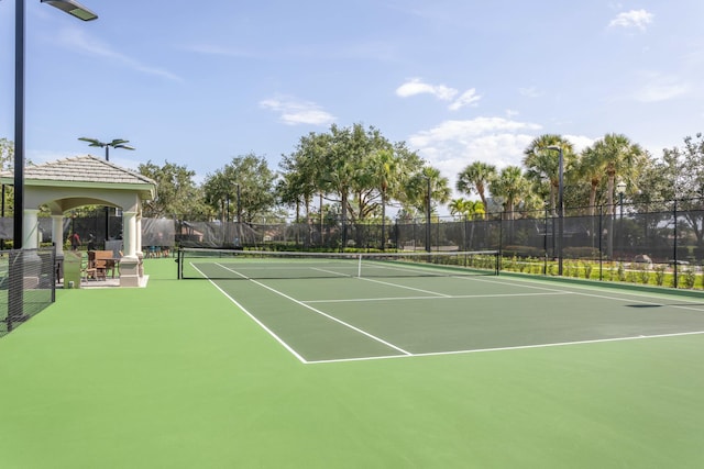 view of tennis court with fence and a gazebo