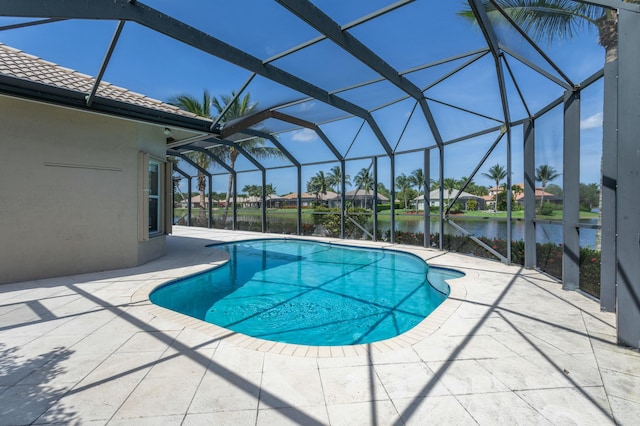 outdoor pool featuring a patio, a water view, and glass enclosure