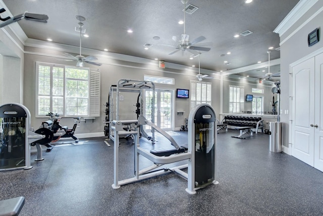 exercise room featuring ornamental molding, visible vents, a textured ceiling, and baseboards