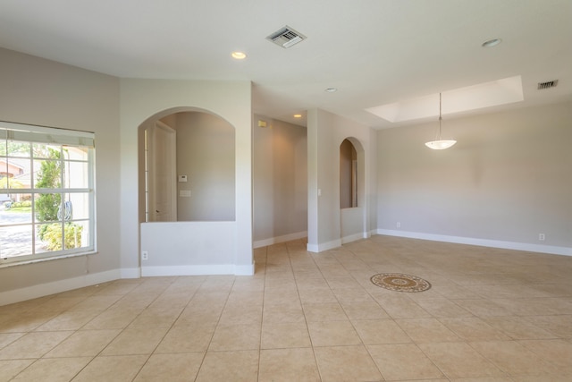 empty room with light tile patterned floors, visible vents, and baseboards