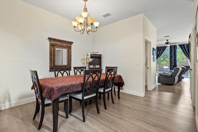 dining space with light hardwood / wood-style flooring and ceiling fan with notable chandelier