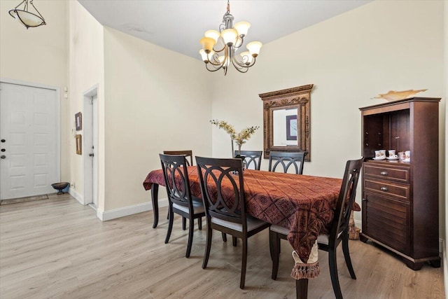 dining area featuring light hardwood / wood-style floors and a notable chandelier