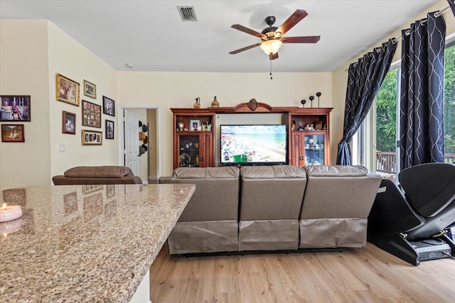 living room featuring light hardwood / wood-style flooring and ceiling fan