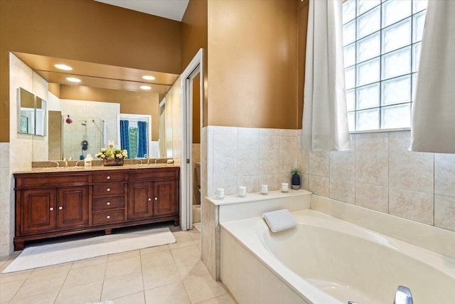 bathroom with tile patterned flooring, vanity, a healthy amount of sunlight, and plus walk in shower