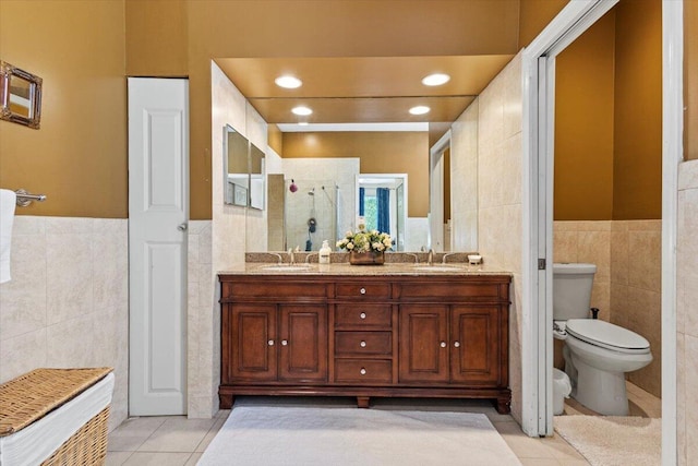 bathroom featuring vanity, tile patterned floors, toilet, tile walls, and an enclosed shower