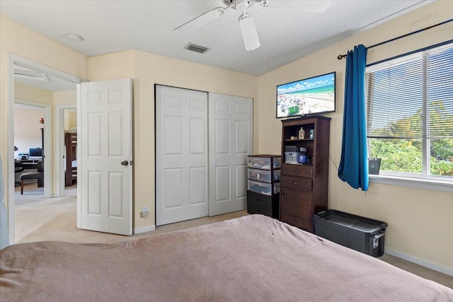 carpeted bedroom with ceiling fan and a closet