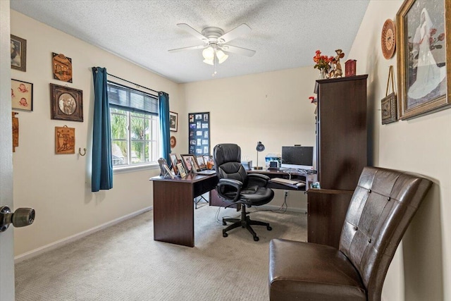 carpeted home office featuring a textured ceiling and ceiling fan