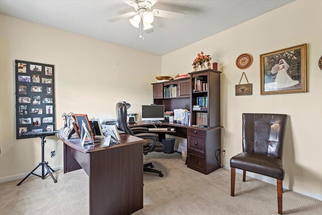 carpeted office space with ceiling fan and a textured ceiling