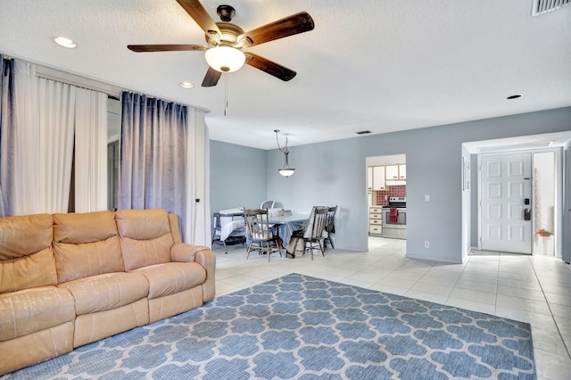 living room featuring ceiling fan and light tile patterned floors