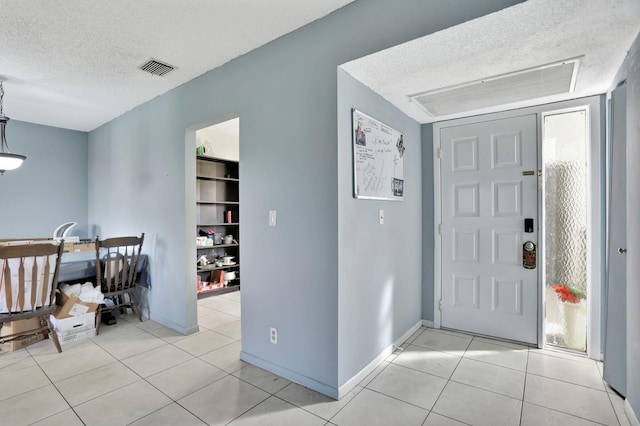 tiled entryway with a textured ceiling