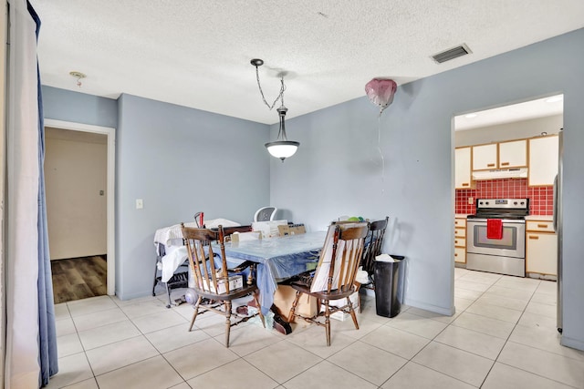 dining room featuring light tile patterned floors and a textured ceiling