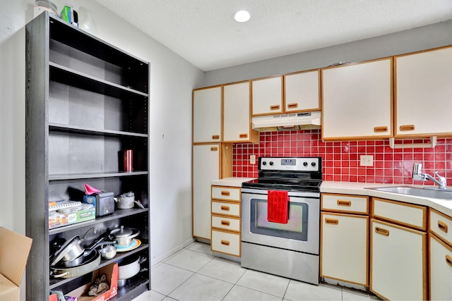 kitchen featuring stainless steel range with electric stovetop, white cabinets, sink, light tile patterned floors, and a textured ceiling