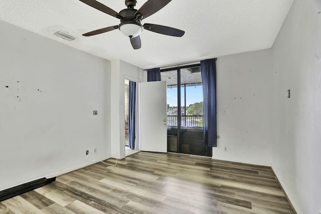 empty room with hardwood / wood-style floors, a textured ceiling, and ceiling fan