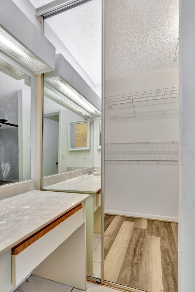 bathroom featuring a textured ceiling, vanity, and hardwood / wood-style flooring