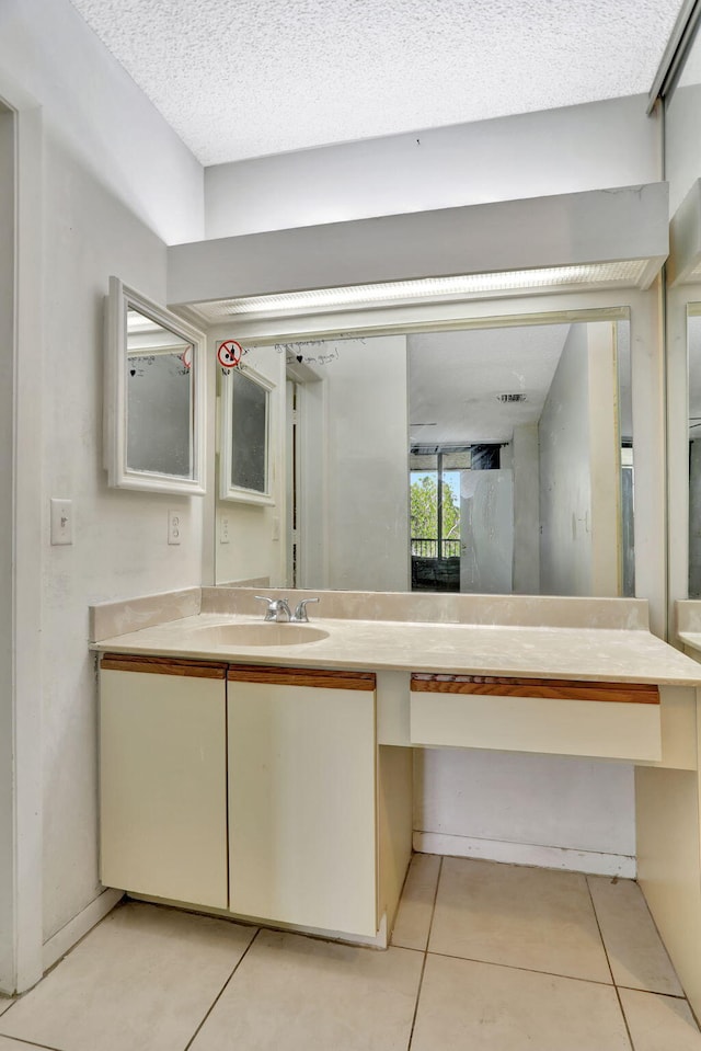 bathroom featuring tile patterned flooring, vanity, and a textured ceiling