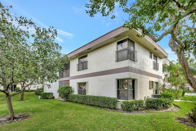 4707 Carambola Cir N Unit 2788, Coconut Creek, FL 33066 - view of property exterior with stucco siding, a balcony, and a yard