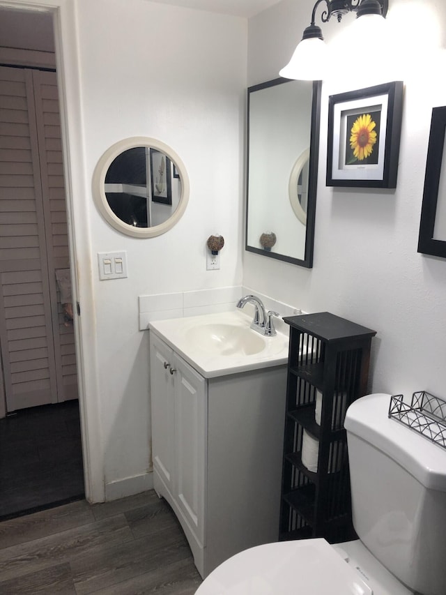 bathroom with vanity, hardwood / wood-style flooring, and toilet