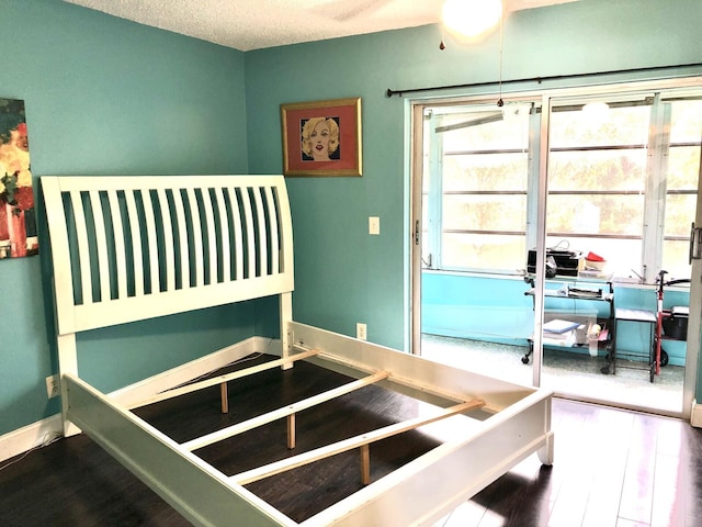 bedroom with hardwood / wood-style floors and a textured ceiling