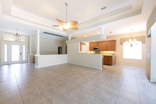 unfurnished living room with a healthy amount of sunlight and a raised ceiling