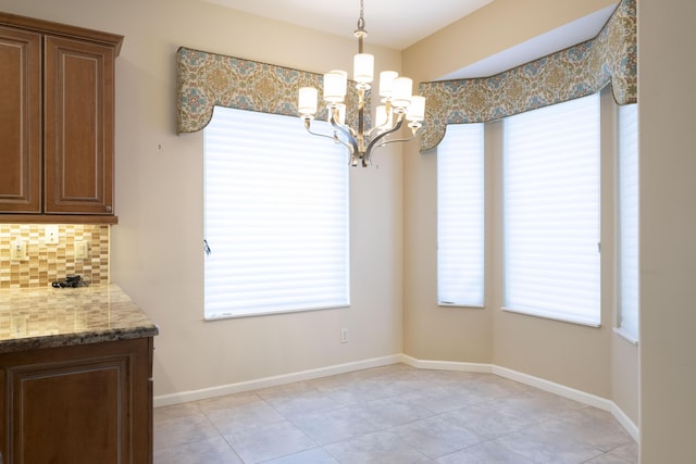 unfurnished dining area with light tile patterned flooring and a chandelier