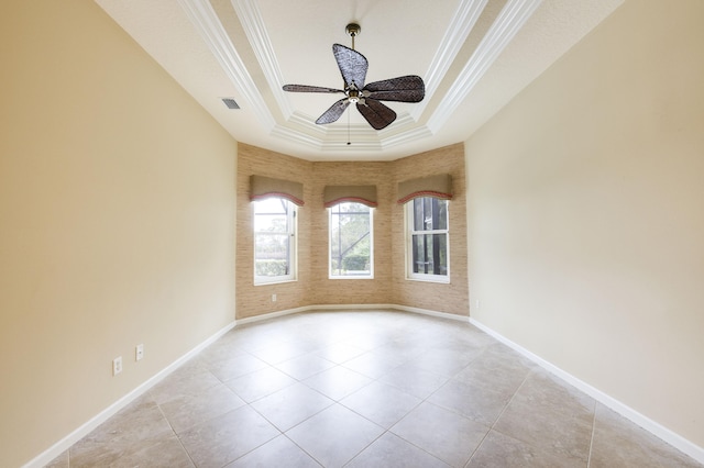 spare room with ceiling fan, light tile patterned floors, a tray ceiling, and crown molding