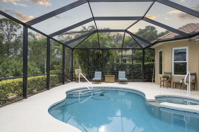 view of pool featuring a lanai, a patio area, and an in ground hot tub