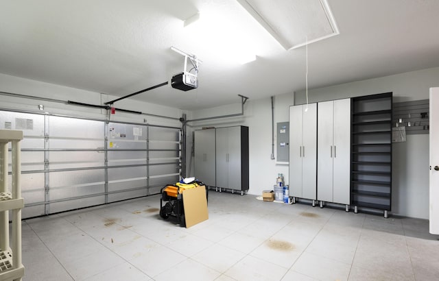 garage with a garage door opener and electric panel