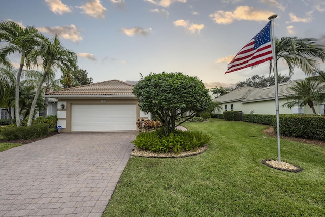 view of front of home with a garage and a yard