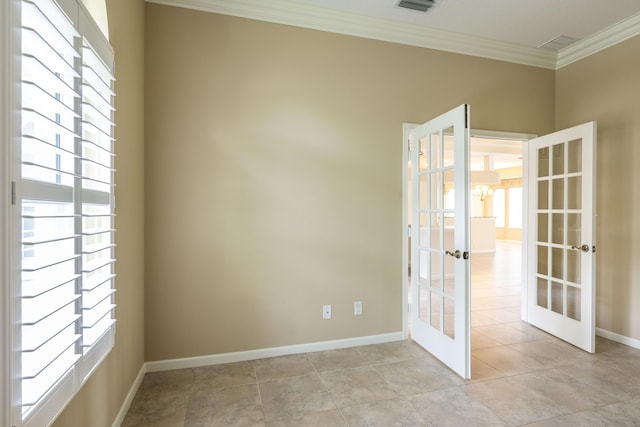 tiled spare room with ornamental molding, a chandelier, and french doors