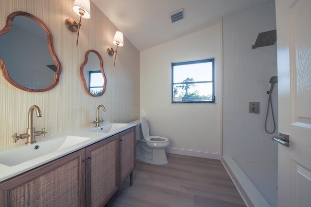 bathroom featuring vanity, a shower, vaulted ceiling, toilet, and wood-type flooring