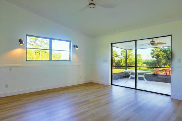 spare room featuring crown molding, ceiling fan, lofted ceiling, and light wood-type flooring