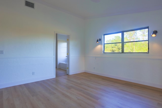 empty room with light hardwood / wood-style floors and ornamental molding