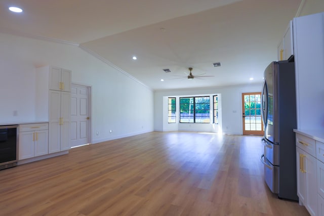 unfurnished living room featuring crown molding, lofted ceiling, and light wood-type flooring