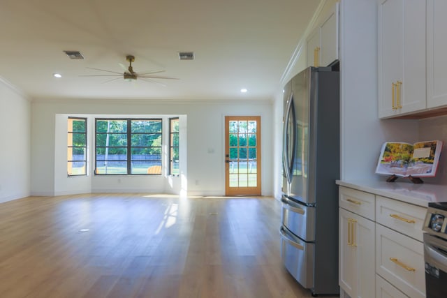 kitchen with ceiling fan, white cabinetry, stainless steel appliances, and ornamental molding