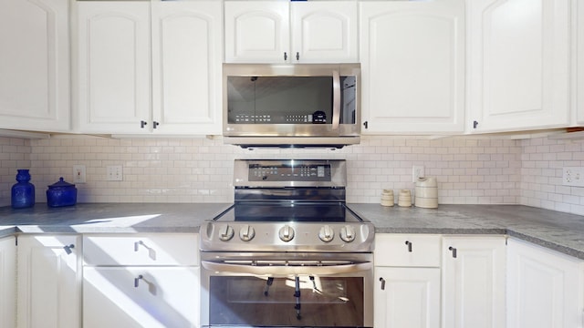 kitchen with white cabinets, backsplash, and stainless steel appliances