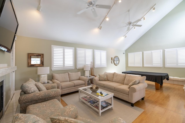 living room featuring billiards, vaulted ceiling, ceiling fan, light wood-type flooring, and a fireplace