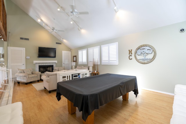 playroom with high vaulted ceiling, a tile fireplace, light hardwood / wood-style flooring, ceiling fan, and pool table