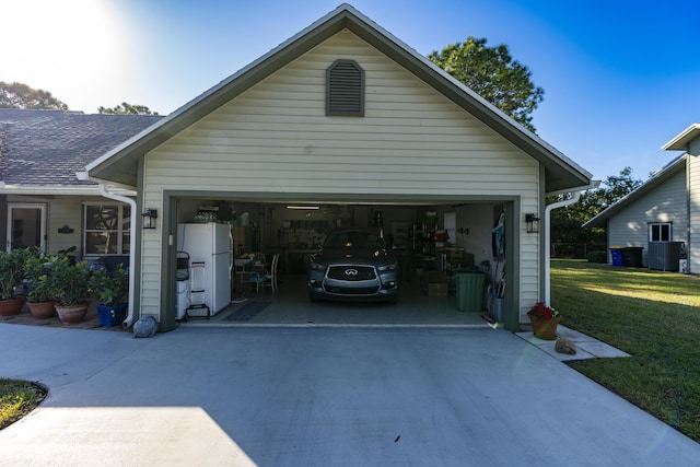 garage featuring a lawn and white fridge