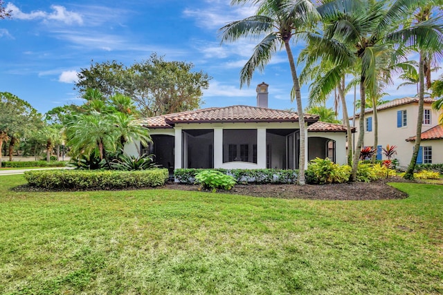 back of property with a sunroom and a yard