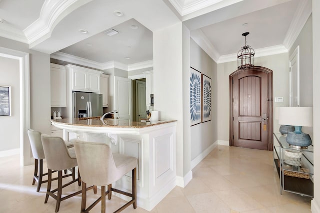 kitchen featuring white cabinets, kitchen peninsula, light stone countertops, light tile patterned floors, and stainless steel fridge with ice dispenser