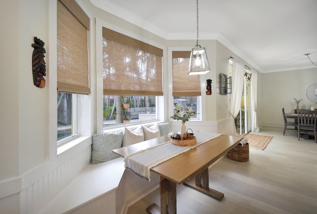 dining room featuring hardwood / wood-style floors, breakfast area, a wealth of natural light, and ornamental molding